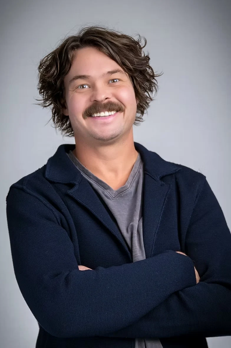 Portrait of Bryan Boyd smiling with his arms crossed