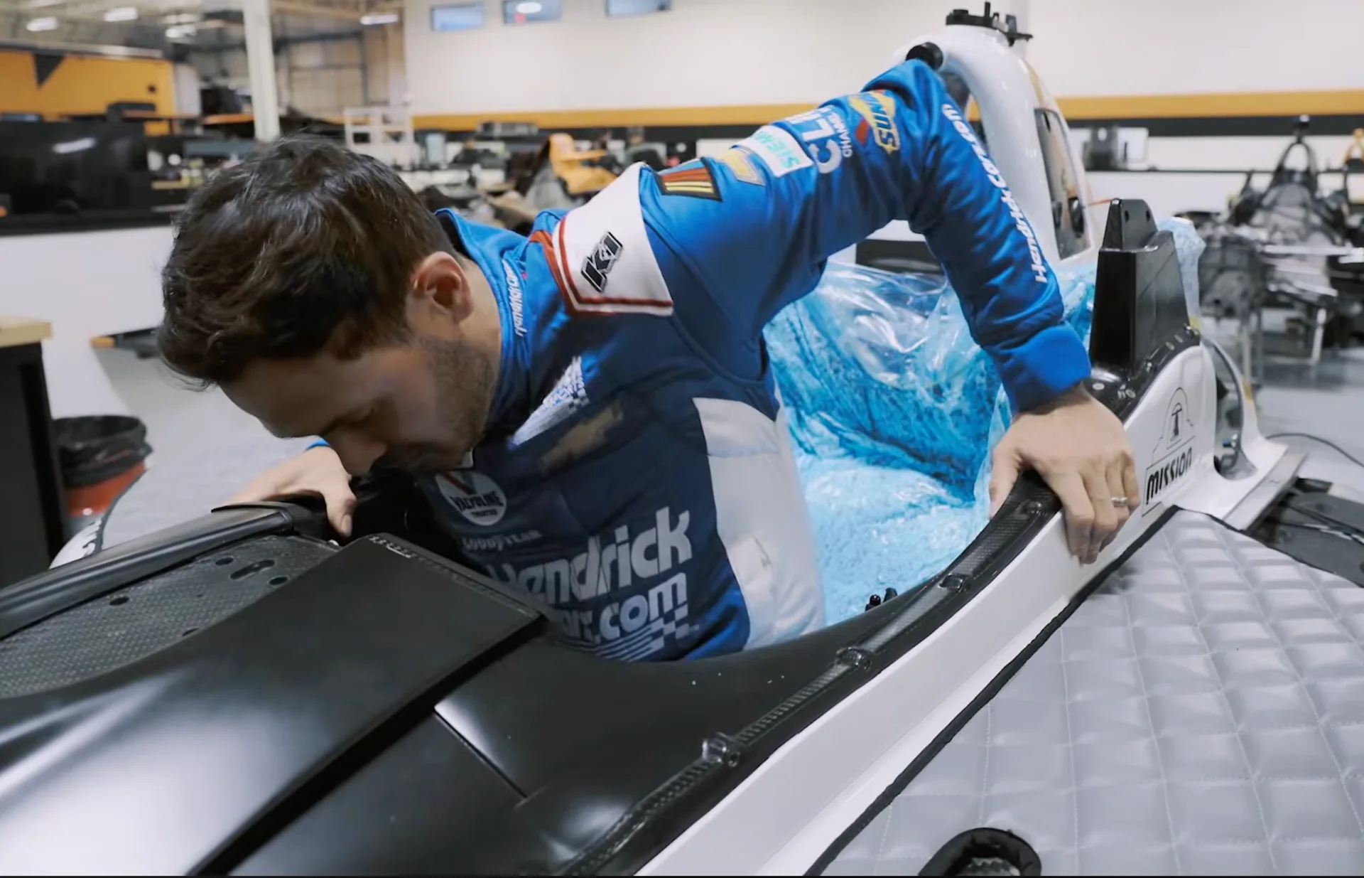 Kyle Larson climbing into his IndyCar